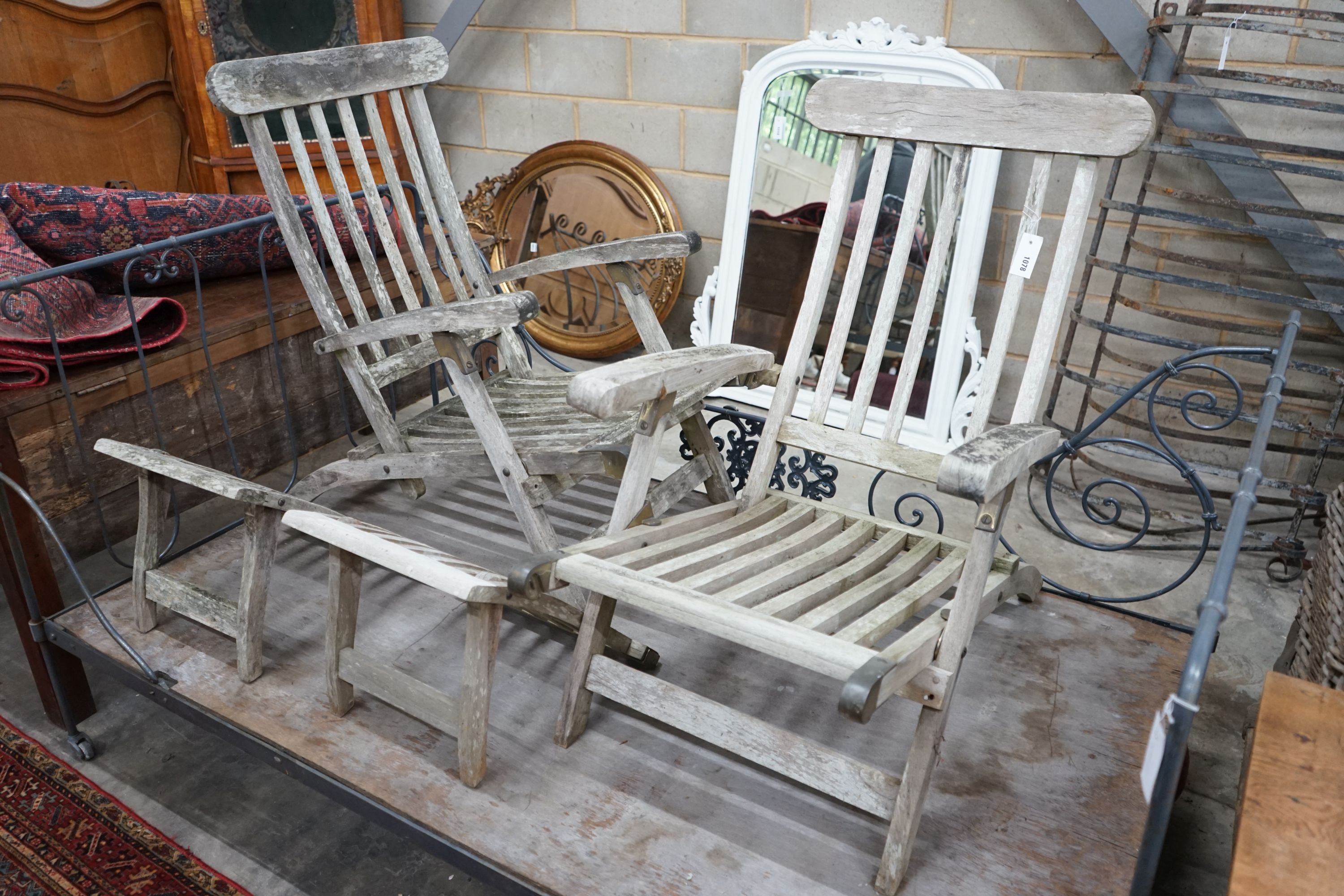 A pair of weathered teak garden steamer chairs (both a.f.)